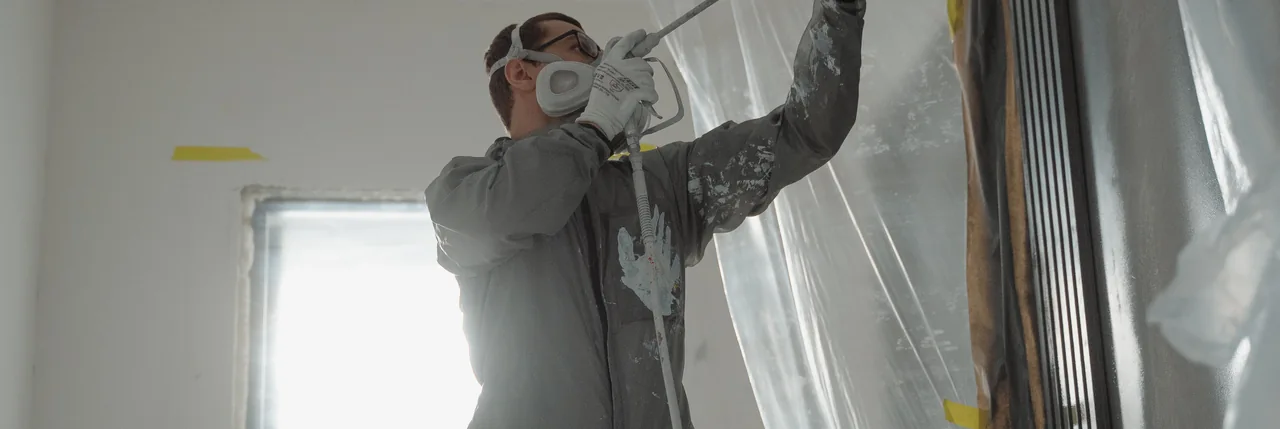 Painter at work with protective equipment. Illustrative stock photograph, not a Backbone customer.